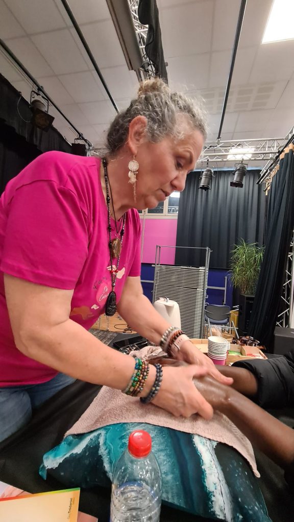 Véronique pratiquant la réflexologie palmaire lors d'un atelier
