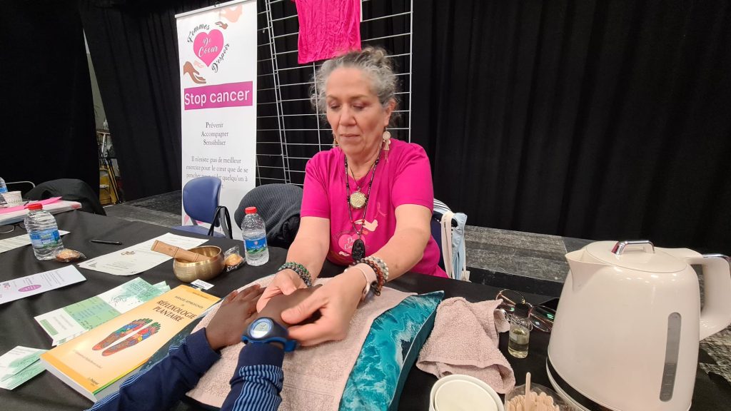 Véronique pratiquant la réflexologie palmaire sur un salon bien-être