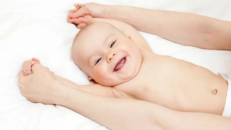 Bébé souriant et détendu après une séance de réflexologie